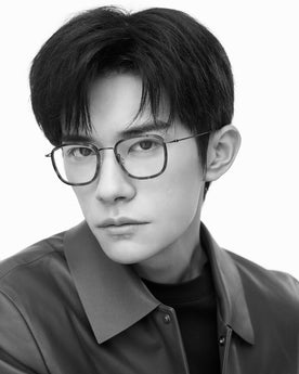 Close-up monochrome portrait of a model wearing thin, lightweight titanium eyeglasses with a refined minimalist aesthetic
