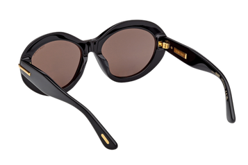 Tom Ford FT1328-F (01A) sunglasses in shiny black acetate shown angled from above, featuring round oversized lenses and signature gold “T” temple detail – available at Lifestyle Optical, Westfield Sydney (Level 2, next to Honey Birdette).