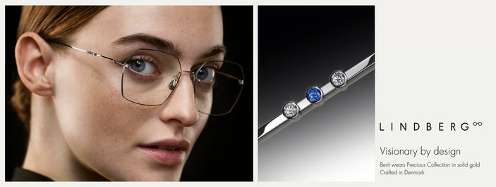 Close-up of model wearing LINDBERG Precious Collection eyewear in solid gold, featuring diamond and sapphire temple detail, showcasing refined Danish minimalist design